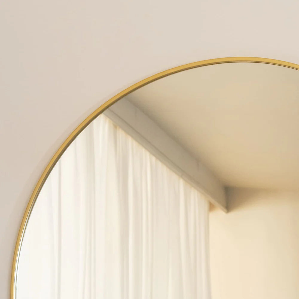 Circular mirror with a thin gold frame. - Horizon and Stone 